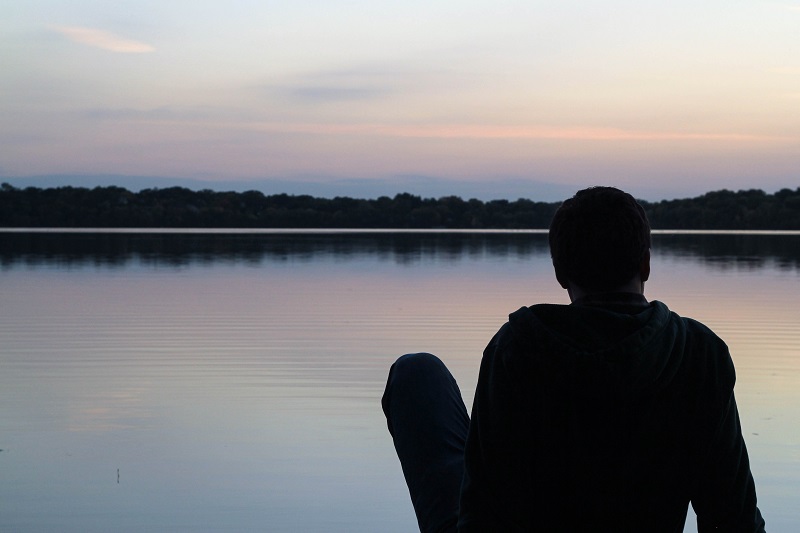 Man sitting looking at water